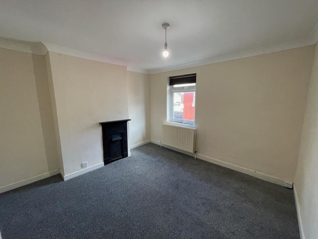 Lot: 107 - TWO-BEDROOM TERRACE HOUSE - Bedroom one with feature fireplace and window to front